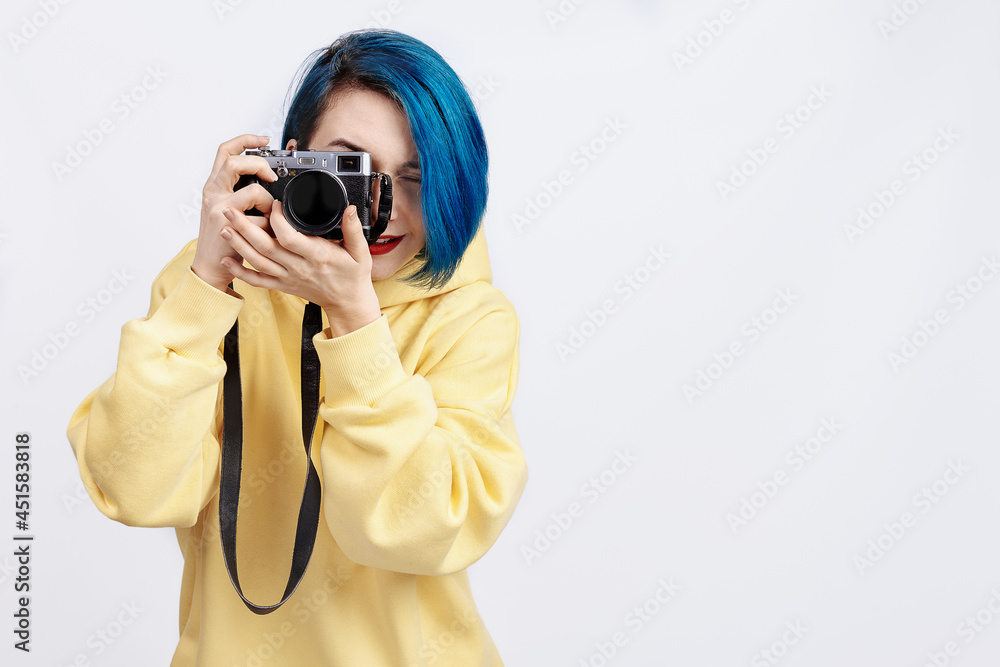 A female photographer in yellow hoody holding a camera A female photographer in yellow hoody holding a camera