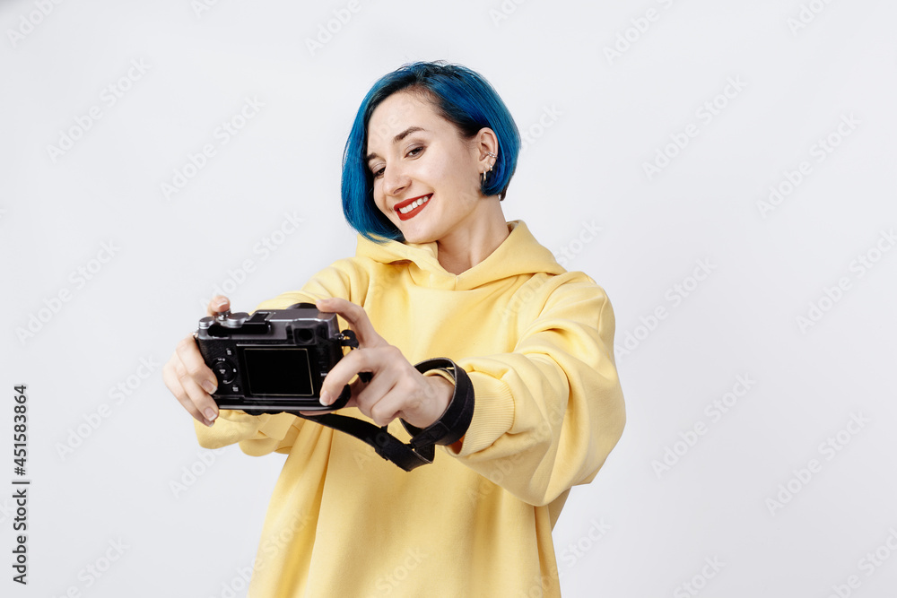 A female photographer in yellow hoody holding a camera A female photographer in yellow hoody holding a camera