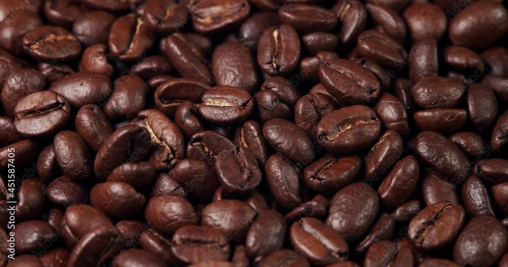 Roasted coffee beans dolly shot. Aromatic coffee beans move slowly. Slide slow motion close-up of whole roasted coffee beans. Roasted coffee beans dolly shot. Aromatic coffee beans move slowly. Slide slow motion close-up of whole roasted coffee beans.