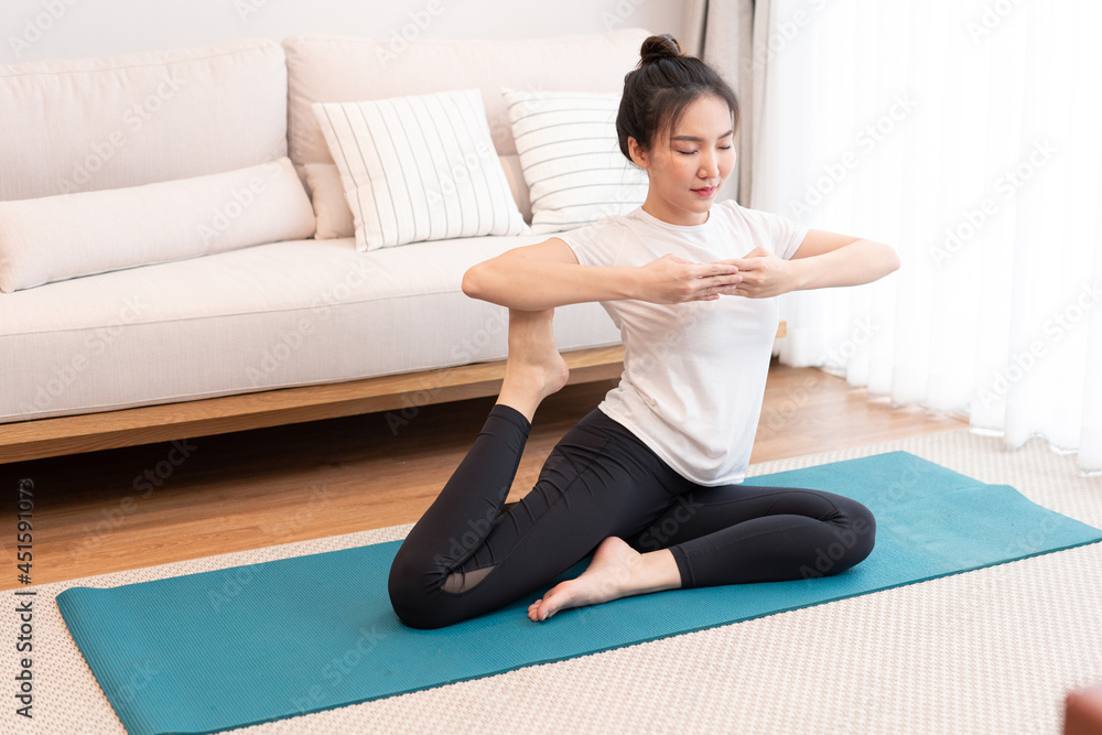 Productive activity concept a girl with a bun wearing the white t-shirt doing the difficult pilates move Productive activity concept a girl with a bun wearing the white t-shirt doing the difficult pilates move