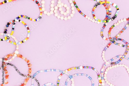Quadro su tela Necklaces and bracelets made from beads and pearls on a purple background