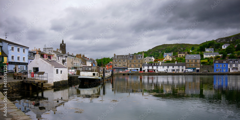 On a grey and overcast afternoon in Tarbert, brightly painted houses and shops border the quay