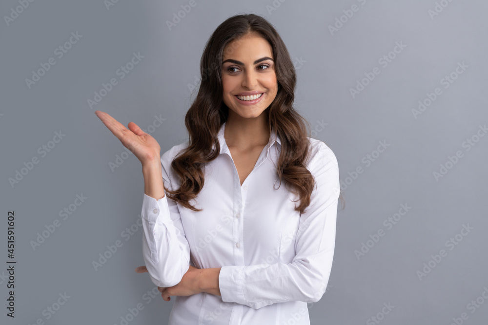 Happy professional woman manager show open hand for copy space grey background, presenting product Happy professional woman manager show open hand for copy space grey background, presenting product