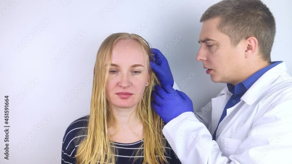 A trichologist examines a girl with oily hair. Problematic scalp and increased secretion of the sebaceous glands. Hair care. Oily hair care and treatment concept. Doctor prescribes treatment. A trichologist examines a girl with oily hair. Problematic scalp and increased secretion of the sebaceous glands. Hair care. Oily hair care and treatment concept. Doctor prescribes treatment.