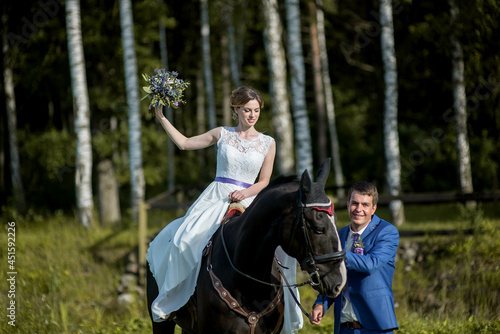 Happy woman bride is ridding the horse