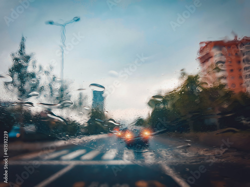 Blurry cars and lights in traffic in a rainy evening seen through windscreen. Traffic in highway in a rainy day.