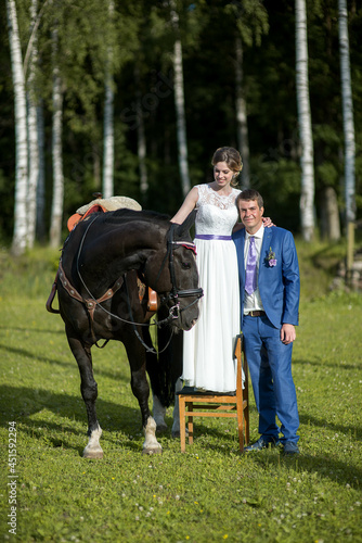 Happy wedding couple with dark horse