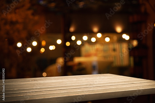 empty wooden table on blurred light gold bokeh cafe restaurant bar, place for your products on the table. © Egor