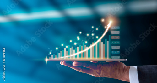 Analysis invest strategy data online connection technology. Businessman hand holding tablet showing graph growth stock hologram chart diagram, forex chart. Business finance and Market trading concept.