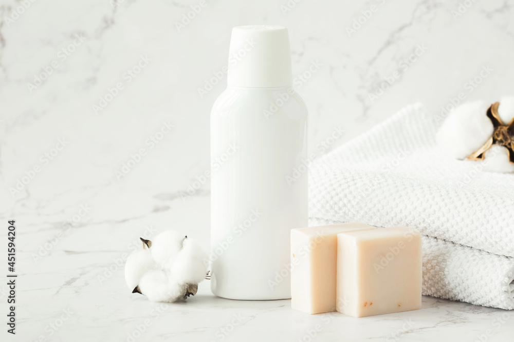 Empty white cosmetic container, jar, soap and towels on shelf in bathroom. A set of cosmetics for face and body care. Copy space. Empty white cosmetic container, jar, soap and towels on shelf in bathroom. A set of cosmetics for face and body care. Copy space.