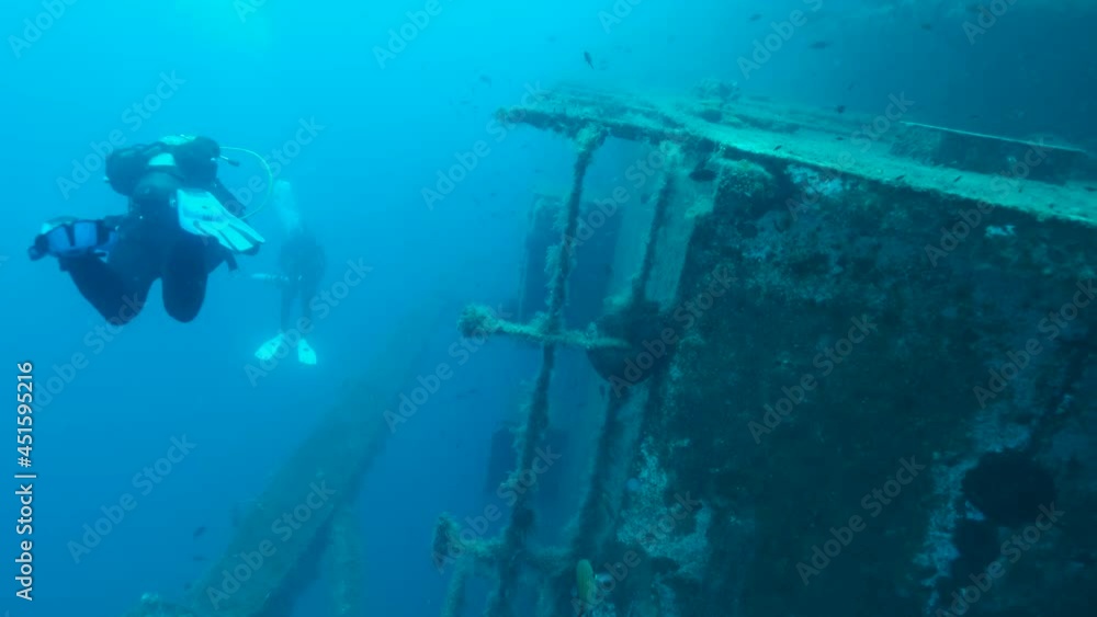 Group scuba divers swims on the Shipwreck Swedish ferry MS Zenobia, a flock of Mediterranean chromis fish swims around. Wreck diving. Mediterranean sea, Cyprus Group scuba divers swims on the Shipwreck Swedish ferry MS Zenobia, a flock of Mediterranean chromis fish swims around. Wreck diving. Mediterranean sea, Cyprus