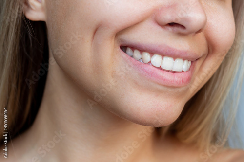 Фотография Cropped shot of a face of a young caucasian smiling blonde woman with dimples on her cheeks