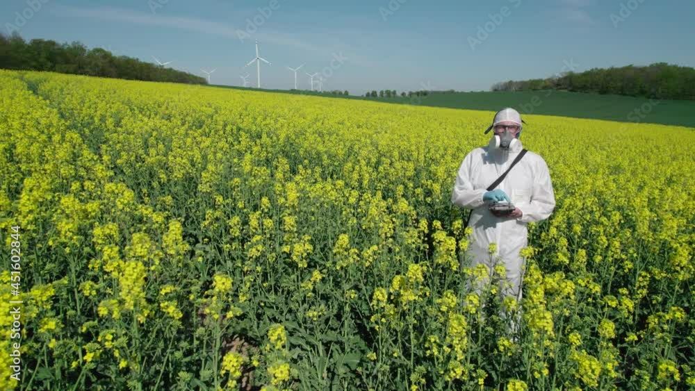 The scientist poses against the background of electric windmills and a farmland. The scientist poses against the background of electric windmills and a farmland.