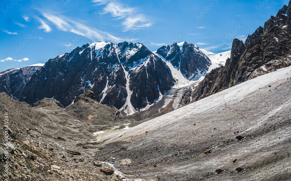 Panoramic view of the glacier, high in the mountains, covered by snow and ice. Altai winter landscape.