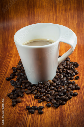 Hot coffee and coffee beans on wood background.
