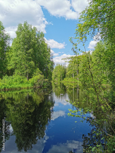 Tohmajoki River in the middle of the forest  which reflects the trees and the sky with clouds  in the mountain park Ruskeala.