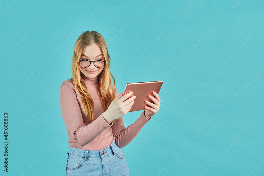 Smart looking girl with glasses. Social media and online communication. Attractive young student with digital tablet isolated on blue background. Smart looking girl with glasses. Social media and online communication. Attractive young student with digital tablet isolated on blue background.