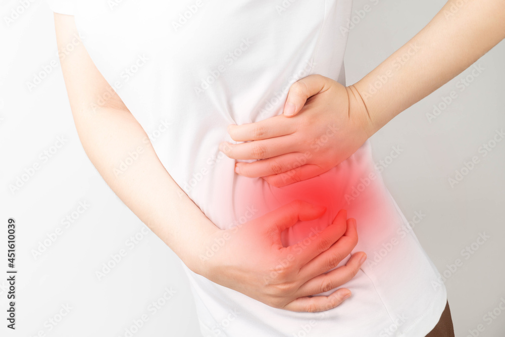 Young woman suffering from backache and flank pain on white background.  Cause of pain include UTI, kidney stones, gallbladder disease or muscle  problems. Health care and medical concept. Stock Photo