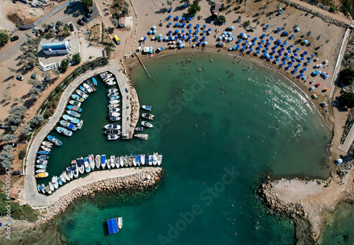 Aerial drone view of beach with people swimming and fishing boats moored at the harbor. Protaras Paralimni Cyprus photo
