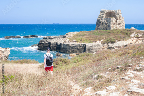 torist walks forward to Torre di Roca Vecchia  on a white cliff of Italian adriatic coast by Mulino d'Acqua Beach by Grotta della Poesia photo