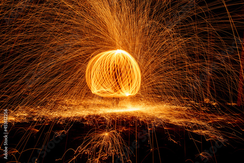 Orange circle moving light fire trails on black background.