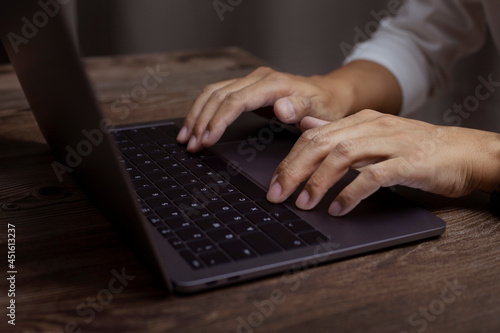 Man typing on laptop or computer concept, Closeup photo of male hands with laptop, businessman working at home office.