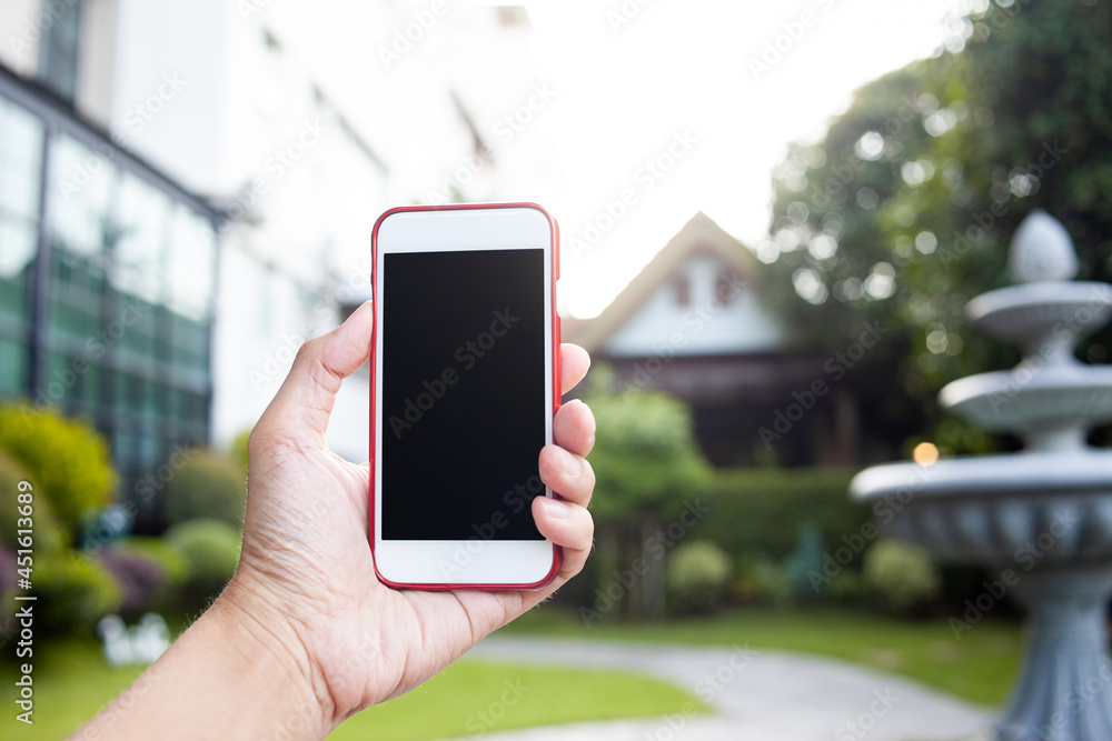 Connection technology background concept, Close up of male hands holding phone with isolated black screen in the garden. 