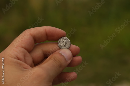 Silver coin of ancient Rome in hand
