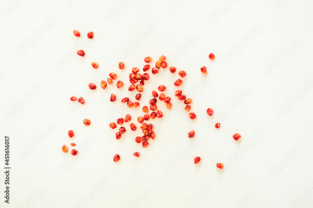Loose pomegranate grains viewed from the top on a white surface Loose pomegranate grains viewed from the top on a white surface