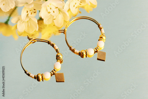 Close up image of handmade modern earrings on mirror background photo