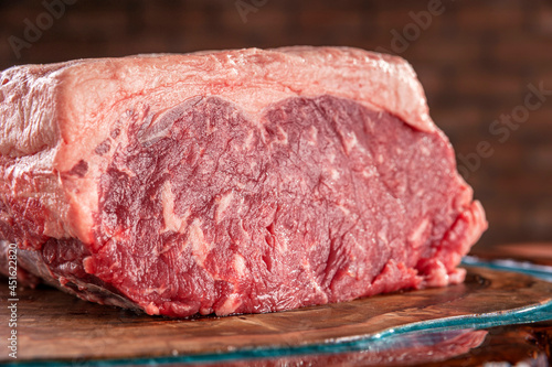 Raw strip loin beef (argentine chorizo) on a wood resined cutting board - Closeup.