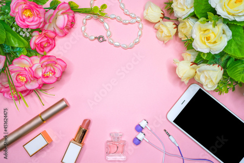 On the table are female accessories, a smartphone, cosmetics, jewelry.