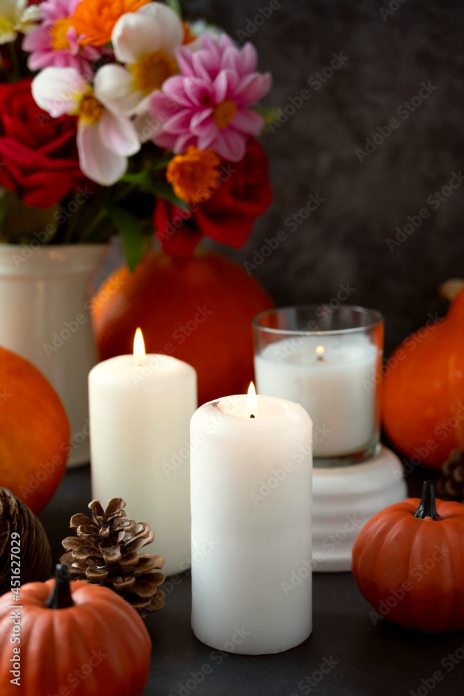 Autumn creative background with candles, autumn flowers, pine cones and pumpkins. Dark moody, cozy fall Autumn creative background with candles, autumn flowers, pine cones and pumpkins. Dark moody, cozy fall