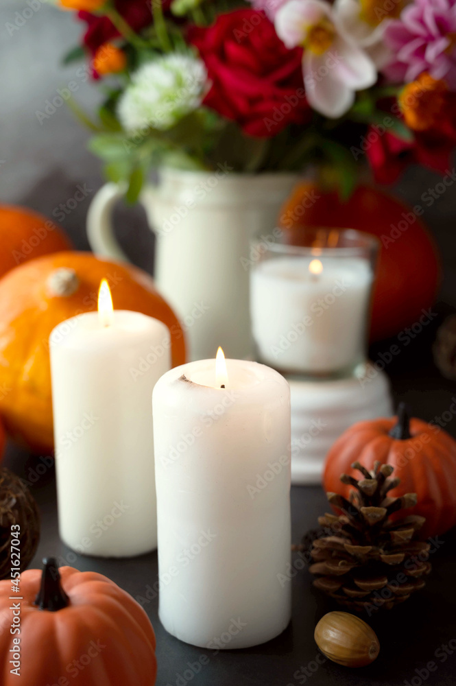 Autumn creative background with candles, autumn flowers, pine cones and pumpkins. Dark moody, cozy fall Autumn creative background with candles, autumn flowers, pine cones and pumpkins. Dark moody, cozy fall