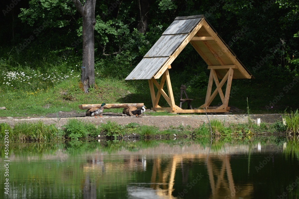 a wooden summer house and their reflection in the lake