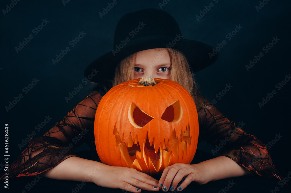 Girl with jack-o-lantern in front of face. Carved halloween spooky pumpkin. Girl with jack-o-lantern in front of face. Carved halloween spooky pumpkin.