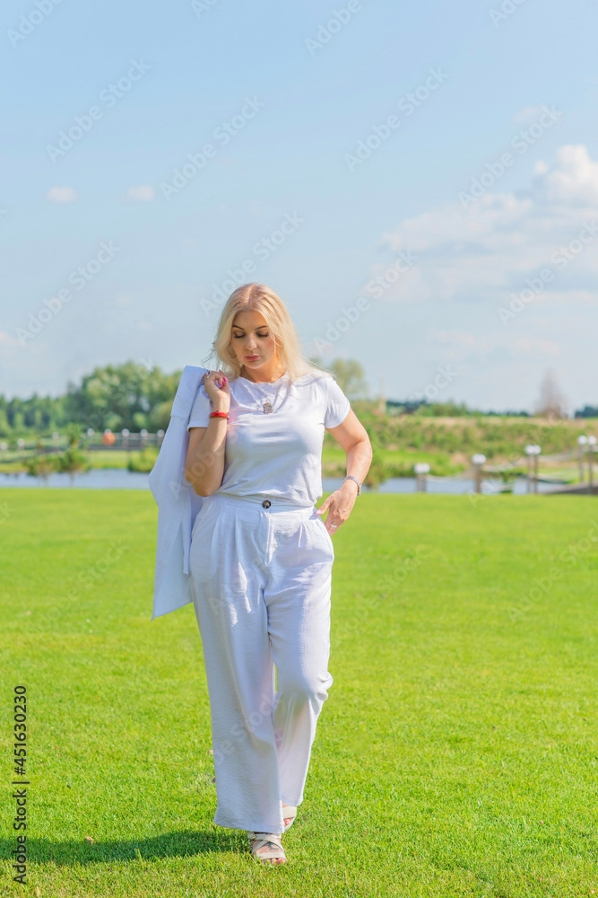 Blonde woman of plus size, American or European appearance walks at golf field, enjoying life. Young lady with excess weight, stylishly dressed at white .Natural beauty Blonde woman of plus size, American or European appearance walks at golf field, enjoying life. Young lady with excess weight, stylishly dressed at white .Natural beauty