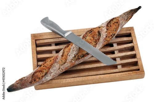 Baguette de pain française sur une planche à pain avec un couteau à pain sur fond blanc photo