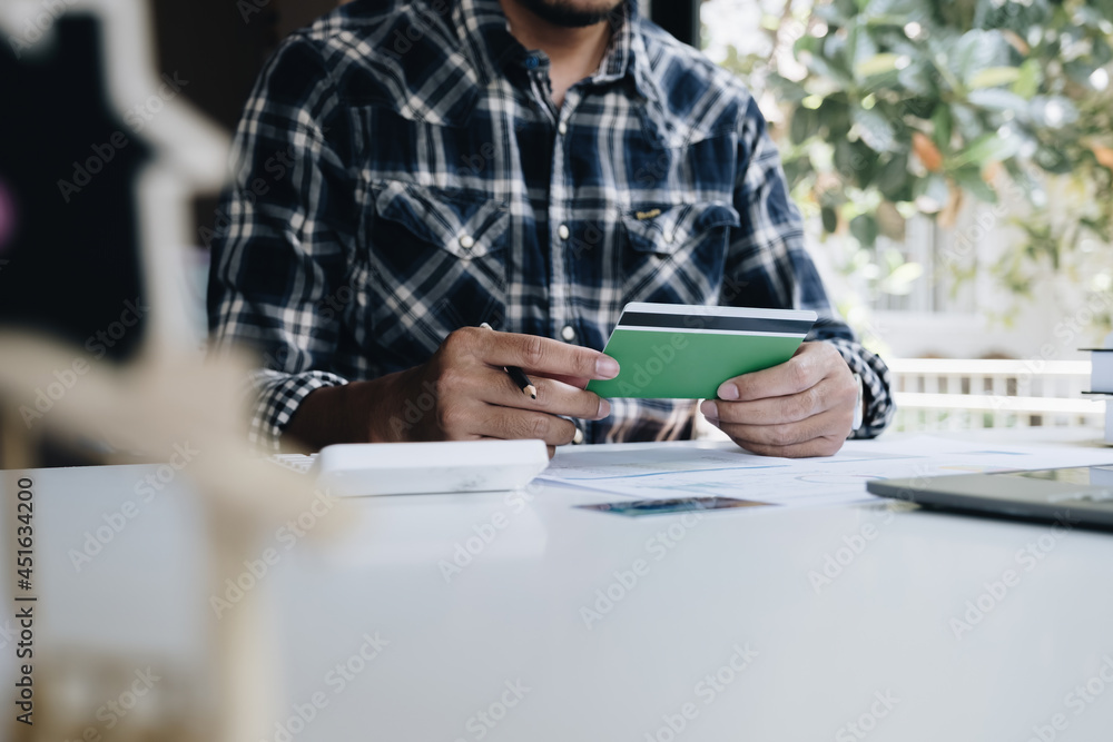 A man with a savings account calculates the amount of money he can save this year. Real Estate and account or saving money or insurance concept. A man with a savings account calculates the amount of money he can save this year. Real Estate and account or saving money or insurance concept.
