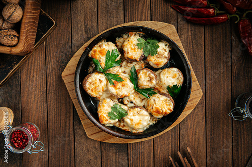 Georgian baked mushrooms with suluguni cheese on a wooden background