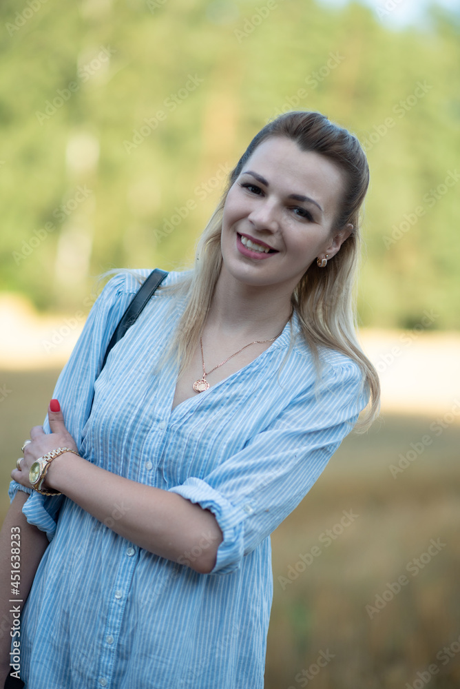 Portrait of a young beautiful blonde girl in a light dress on the field. Portrait of a young beautiful blonde girl in a light dress on the field.