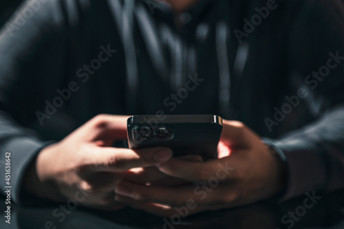 Businessman is working on Smartphone. stock business or work from home concept. dark tone