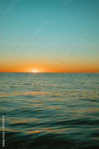 Fototapeta Naklejka Na Ścianę i Meble -  Sun rising over the water at Mollymook Beach.