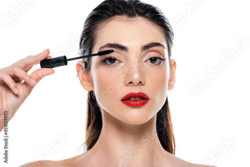 young woman applying mascara isolated on white