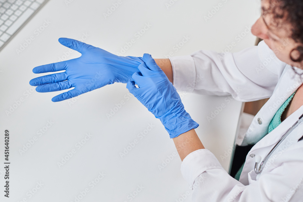 Top view of a female doctor putting on gloves Top view of a female doctor putting on gloves