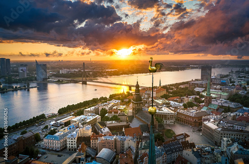  Incredible sunset over the Old town of Riga. Colorful sunlight shines over the rooftops of historic buildings and impressive church tower. 