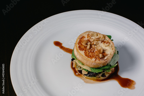 A close-up of a plate with the classic Spanish dish Timbal de Bacalao.  Haute cuisine main course plate. photo