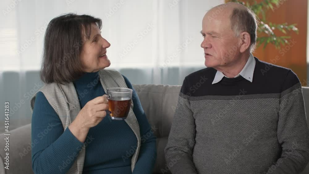joyful married couple who retained tender feelings are imbued with joint tea drinking with sandwiches and cheerful conversation