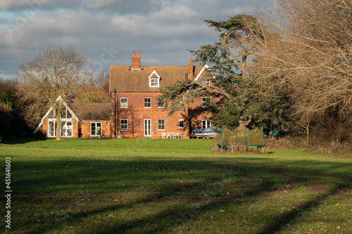 A house and garden in the countryside in winter sunlight, UK