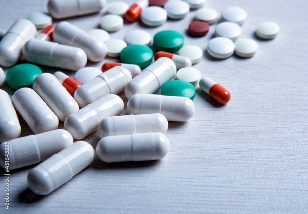 multicolored medical pills are scattered on the table multicolored medical pills are scattered on the table